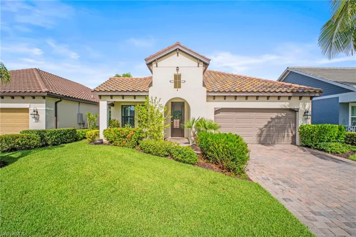 Mediterranean / spanish house featuring stucco siding, a tile roof, decorative driveway, and an attached garage