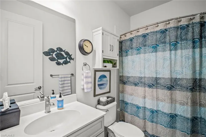 Bathroom featuring vanity and curtained shower