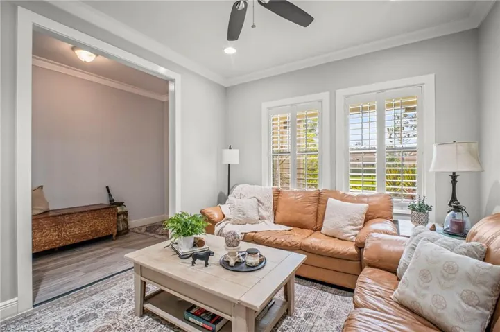 Living room with ornamental molding, wood finished floors, ceiling fan, and recessed lighting