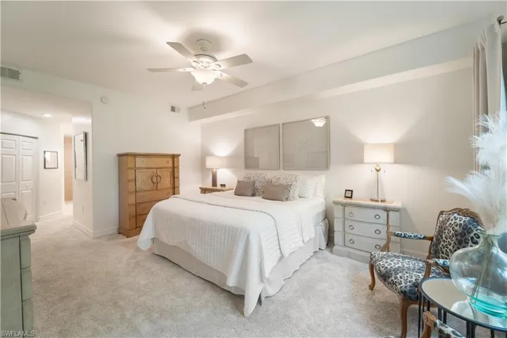 Bedroom with light carpet, ceiling fan, and a closet