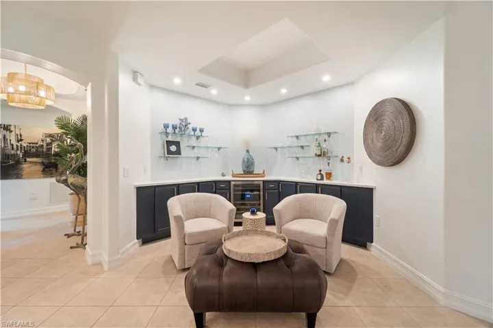 Sitting room featuring indoor bar, beverage cooler, and light tile patterned floors