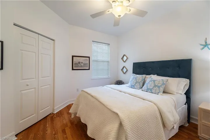 Bedroom featuring dark wood-type flooring, ceiling fan, and a closet