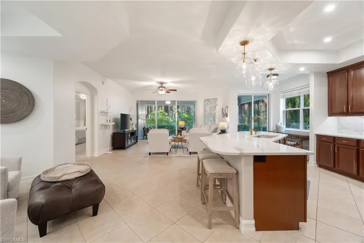 Kitchen featuring hanging light fixtures, a kitchen island with sink, sink, and plenty of natural light