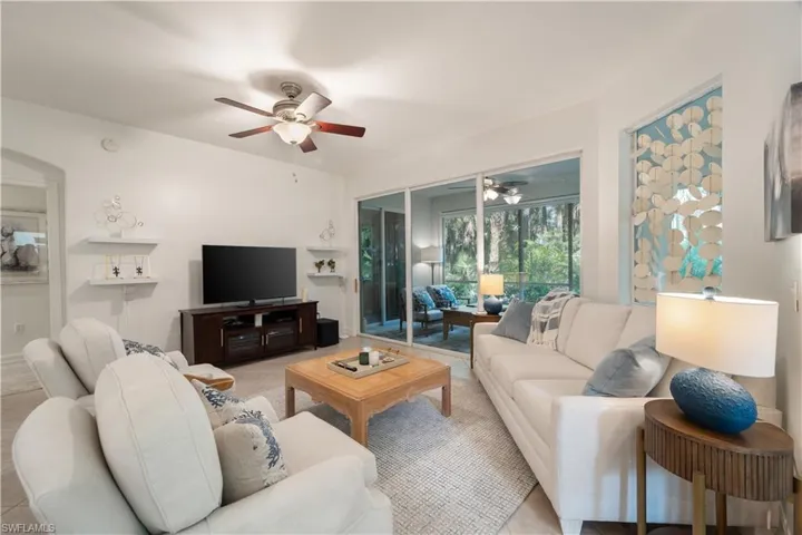 Living room featuring light tile patterned floors and ceiling fan