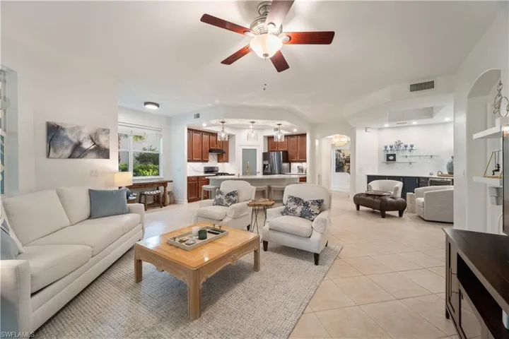 Living room with ceiling fan and light tile patterned floors