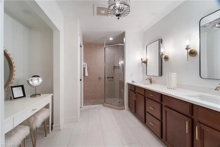 Bathroom with vanity, a shower with shower door, and tile patterned flooring