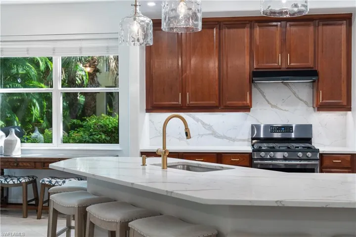 Kitchen featuring pendant lighting, a wealth of natural light, stainless steel range with gas stovetop, and sink