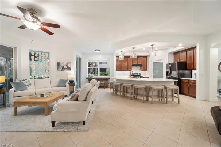 Living room featuring ceiling fan, light tile patterned flooring, and plenty of natural light