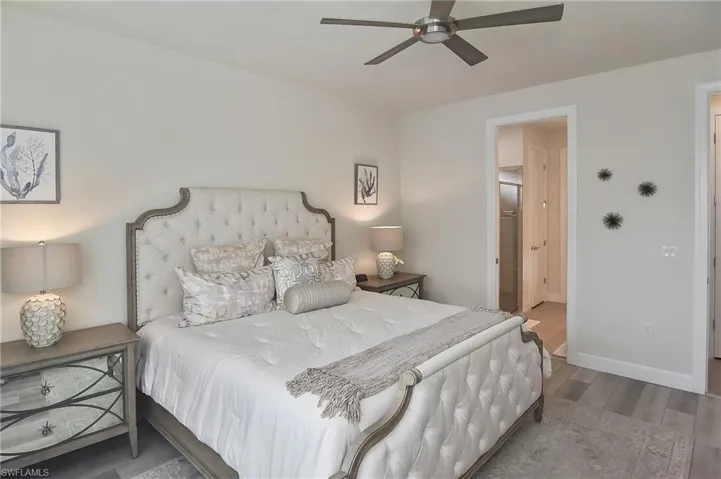 Bedroom featuring wood finished floors, ceiling fan, and ensuite bathroom