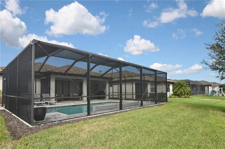 Rear view of property with a lanai, a sunroom, an outdoor pool, and a patio