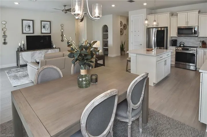 Dining room with recessed lighting, arched walkways, a ceiling fan, and light wood-type flooring