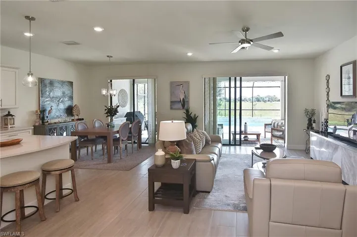 Living room featuring recessed lighting, ceiling fan, light wood-style flooring, and a chandelier