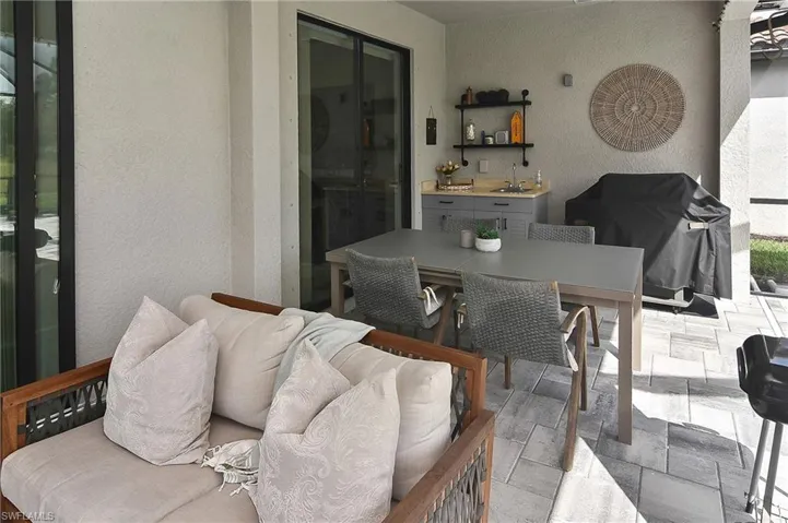 Dining area with a textured wall, stone tile floors, and plenty of natural light