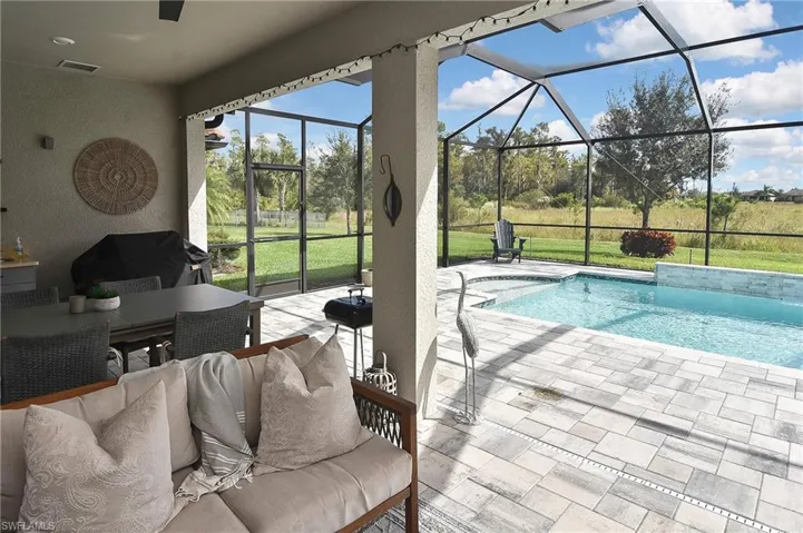 Swimming pool with a sunroom, a lanai, a patio area, and outdoor dining space
