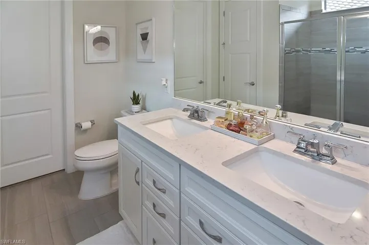 Bathroom featuring double vanity and a stall shower