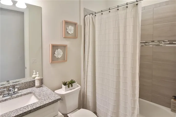 Bathroom featuring vanity and shower / tub combo with curtain