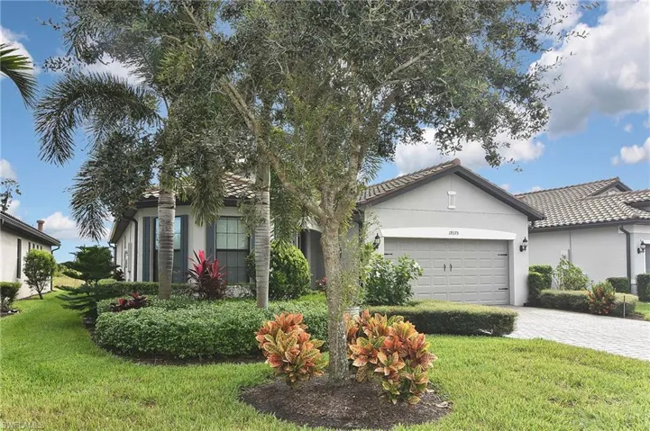 View of front of house featuring a front lawn, stucco siding, decorative driveway, and an attached garage