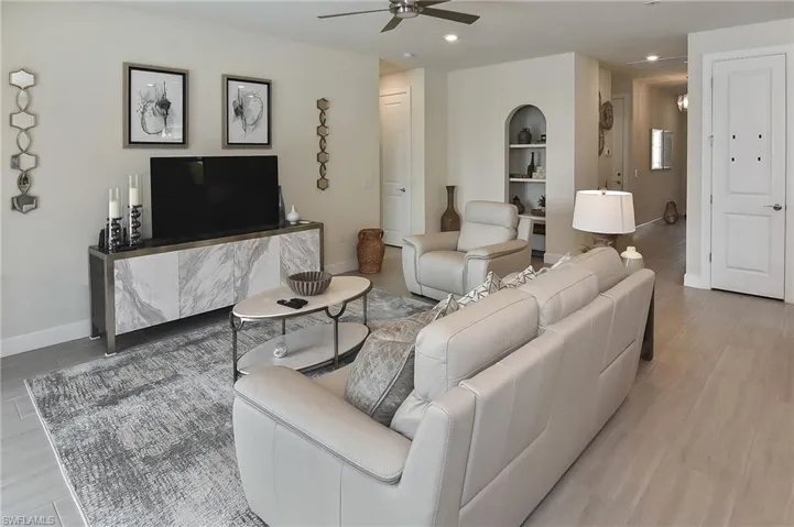 Living room with light wood finished floors, a ceiling fan, and recessed lighting