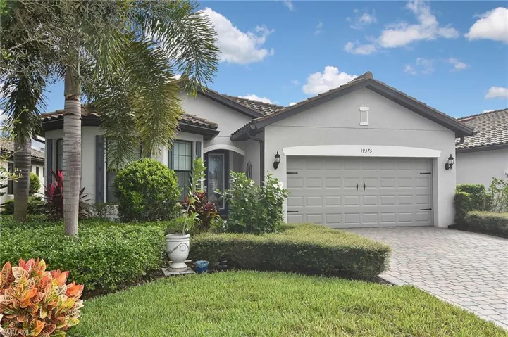 Ranch-style home featuring stucco siding, decorative driveway, a garage, and a tiled roof
