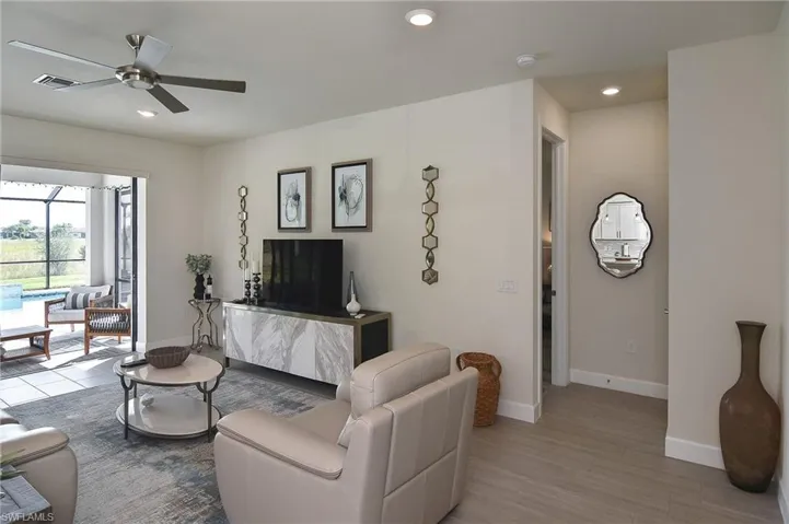 Living room featuring recessed lighting, ceiling fan, wood finished floors, and a sunroom