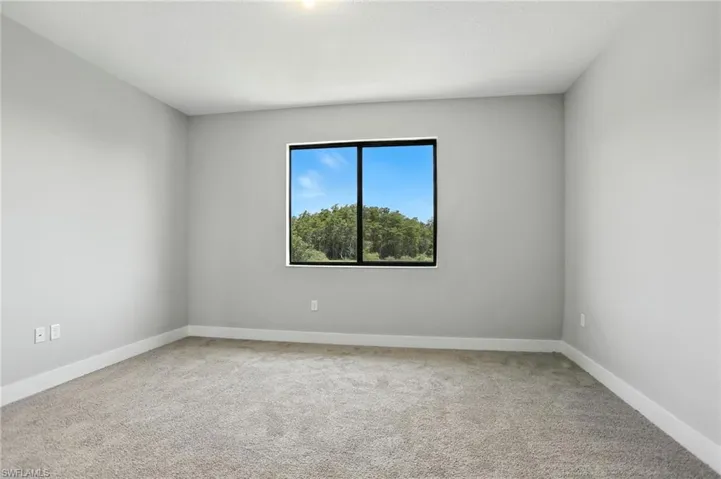 Empty room with light carpet and baseboards