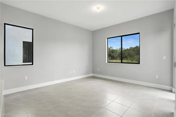 Unfurnished room with baseboards and light tile patterned flooring