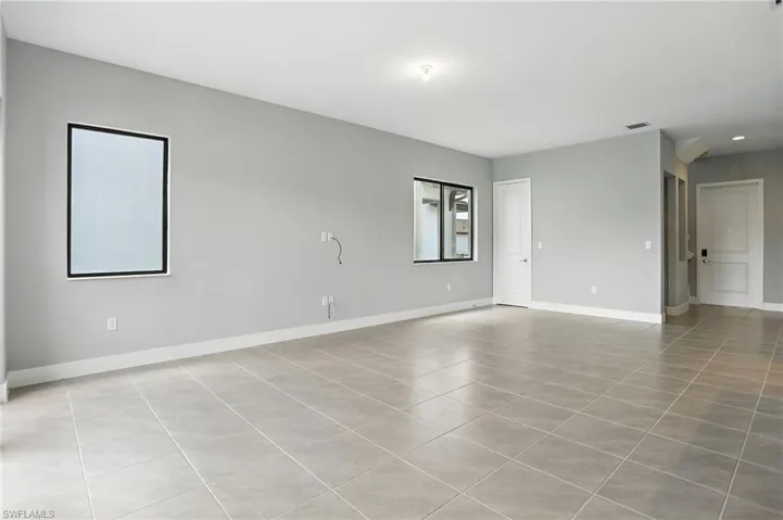Spare room with baseboards and light tile patterned floors