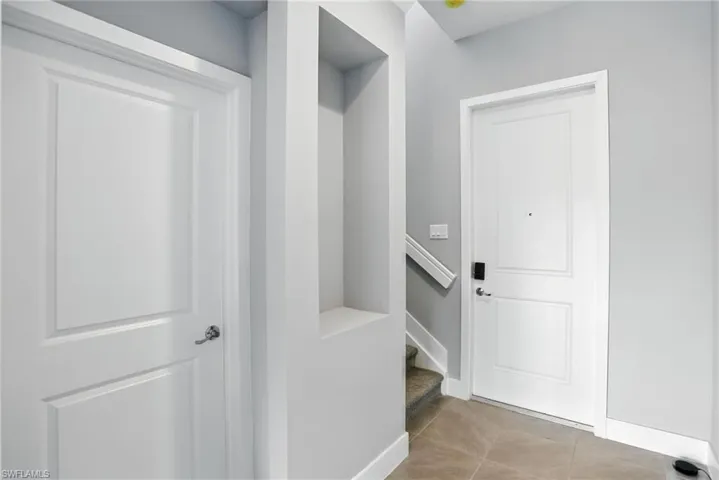 Mudroom with light tile patterned floors and baseboards