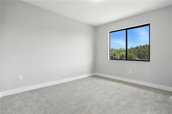 Carpeted spare room with baseboards