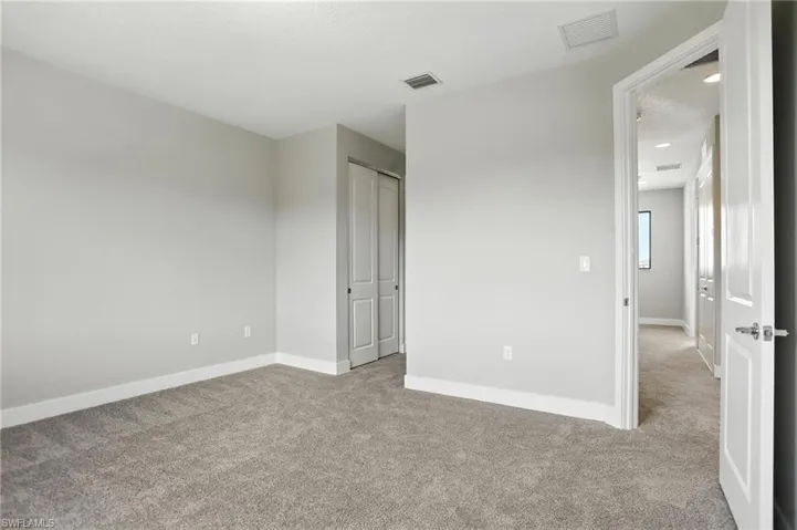 Unfurnished bedroom featuring light carpet, a closet, and a textured ceiling