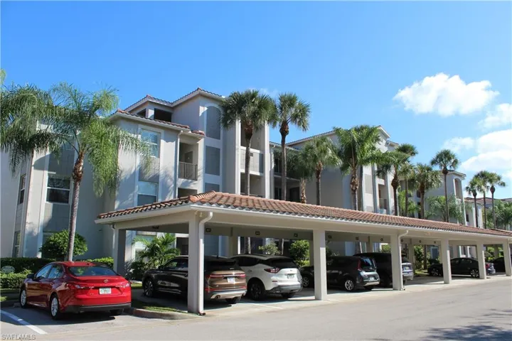 View of building exterior featuring covered parking