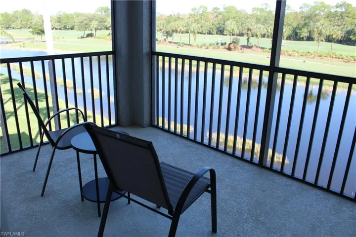 Balcony featuring view of wooded area, a sunroom, golf course view, and a water view