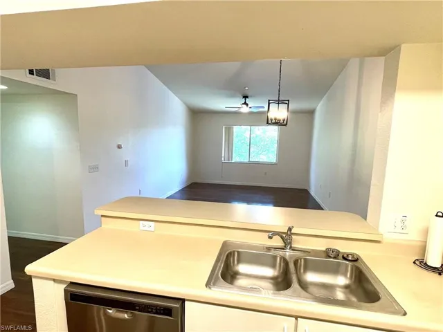 Kitchen with dishwasher, light countertops, a ceiling fan, and open floor plan