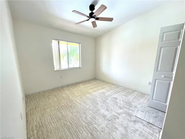 Bedroom featuring new carpet and ceiling fan with walk in closet
