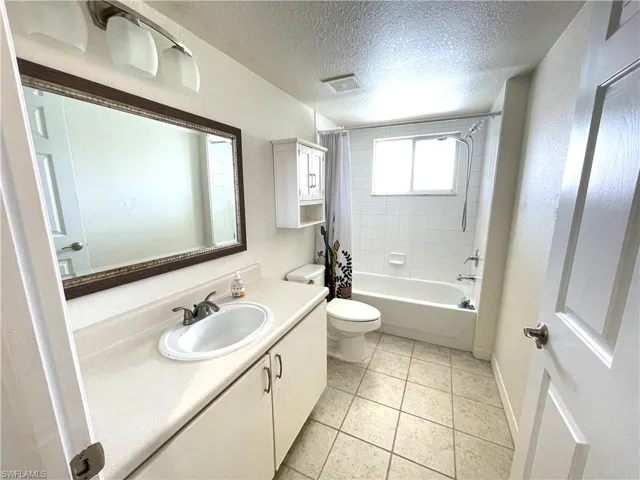 Full bathroom featuring vanity, shower/bath combination, tile flooring