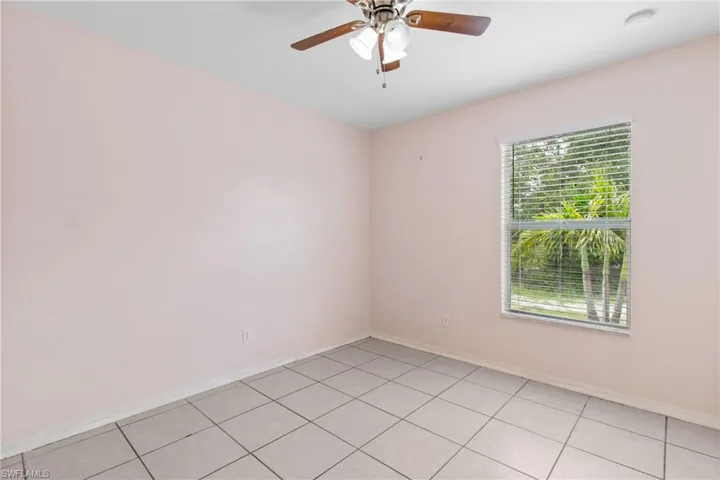 Unfurnished room featuring light tile patterned flooring and a ceiling fan