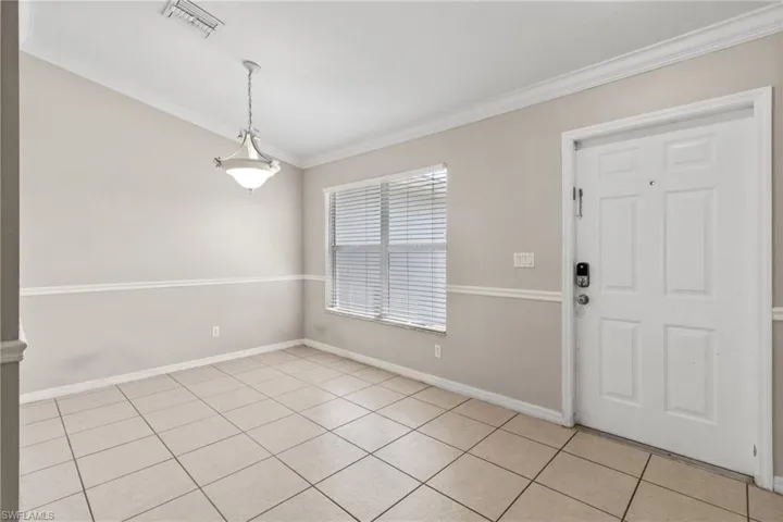 Foyer with ornamental molding and light tile patterned floors