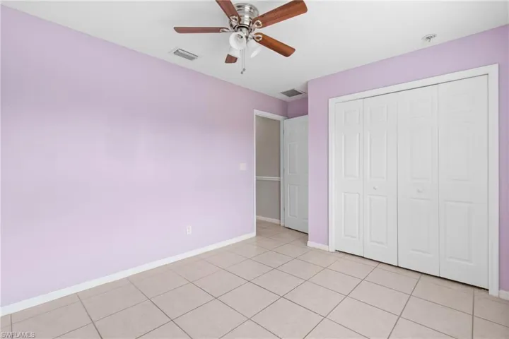 Unfurnished bedroom with light tile patterned floors, a closet, and ceiling fan