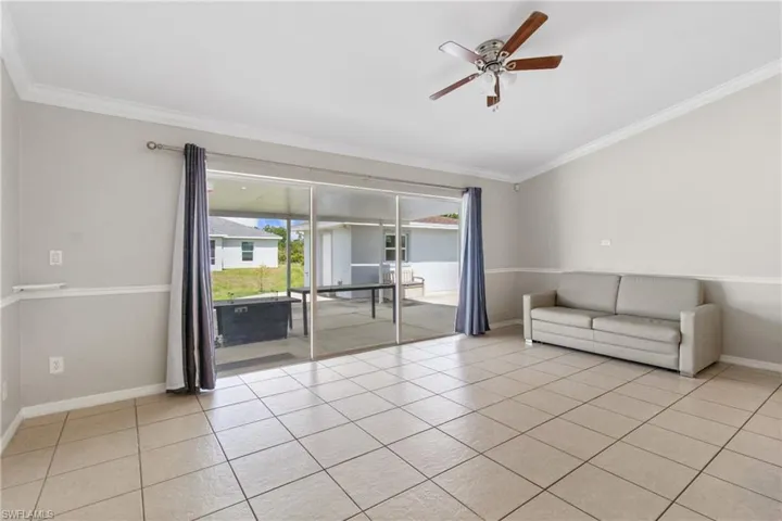 Unfurnished room featuring crown molding, ceiling fan, and light tile patterned floors