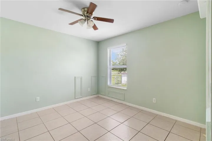 Spare room with a ceiling fan and light tile patterned floors