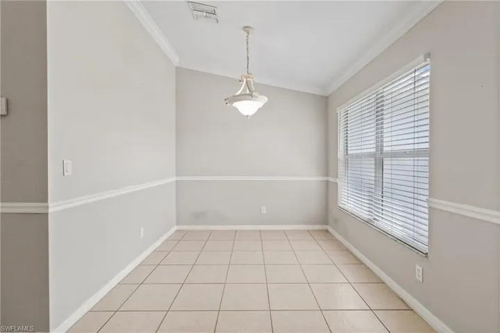Spare room featuring ornamental molding and light tile patterned floors