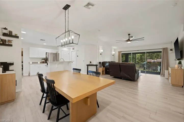 Vaulted ceilings enhance this open-concept living space, featuring wood-finish flooring throughout