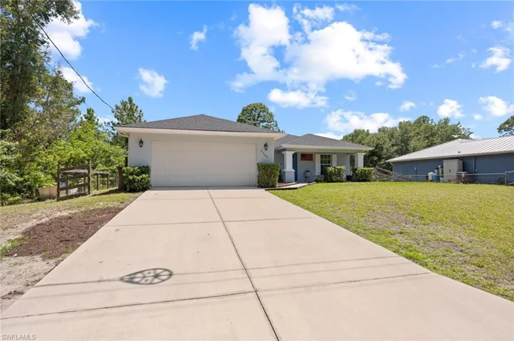 Single-story residence featuring a two-car garage, concrete driveway, and front porch with columns