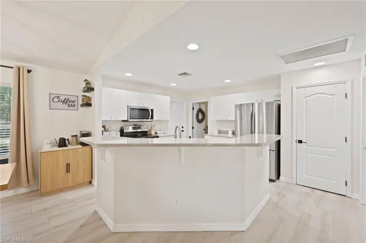 Modern kitchen featuring white cabinetry, light-toned countertops, and stainless steel appliances