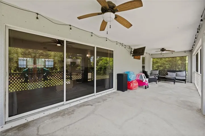 Expansive covered patio featuring a concrete surface and two ceiling fans