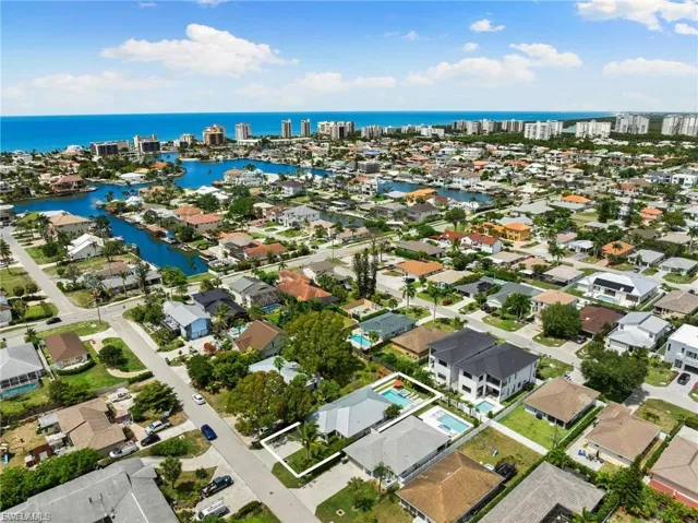 Aerial view of property's location with a nearby body of water and nearby suburban area