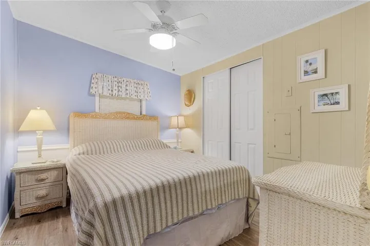 Bedroom featuring hardwood / wood-style floors, ceiling fan, and a textured ceiling