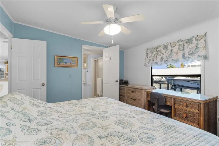Bedroom with vaulted ceiling, ceiling fan, and ornamental molding
