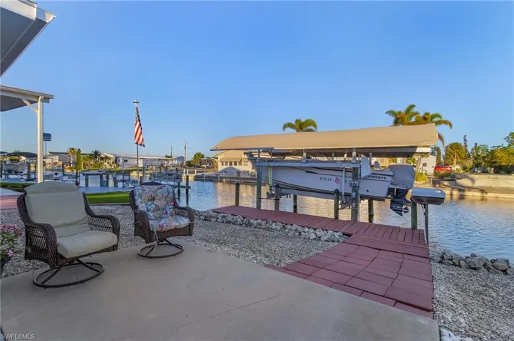 View of patio with a boat dock and a water view