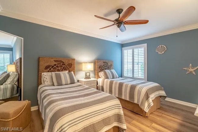 Bedroom featuring crown molding, multiple windows, light wood-type flooring, and ceiling fan